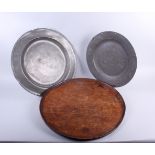 Two pewter chargers and a Victorian circular mahogany table top/serving tray