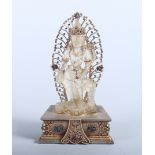 A 19th/early 20th century carved rock crystal deity with applied yellow metal and stone