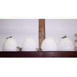 A set of four milk glass oviform ceiling light pendants, 12" high