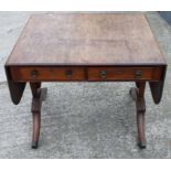 A Regency mahogany sofa table, on four acanthus leaf carved, reeded, splayed supports with brass