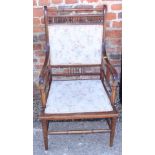 An Edwardian walnut elbow chair with spindle back, on turned supports