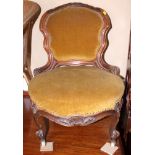 A Victorian carved walnut low seat nursing chair, on scroll supports