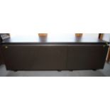 An Interlubke black lacquered low stand, fitted pull-out drawer and cupboard, 66" wide