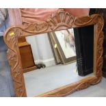 A carved hardwood framed wall mirror with leaf decoration, plate 20" x 24"