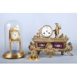 An early 20th century gilt metal mantel clock, with standing man and two painted porcelain panels,