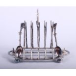 An early 20th century silver plated four-division toast rack and egg stand, the case in the form