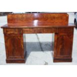 An early 19th century figured mahogany double pedestal sideboard with ledge back over three