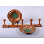 A 19th century turned wood coat rack and two oak alms dishes