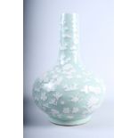 A Chinese celadon bottle vase with applied floral decoration, on pierced hardwood stand, 18" high