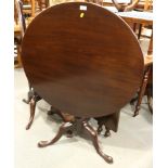 A Georgian mahogany circular tilt top table, on turned column and tripod splay supports with pad