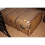 A canvas trunk, a large ebonised tin trunk, two wooden trunks and a wicker basket