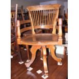 An executive's Edwardian mahogany swivel armchair with shaped seat, on four splayed and castored