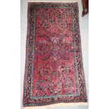 A Persian rug with floral design on red ground, 25" x 46" approx