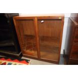 A teak bookcase with adjustable shelves enclosed two glazed doors, 36" wide