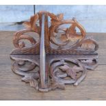 A Black Forest carved folding wall shelf, 11" wide