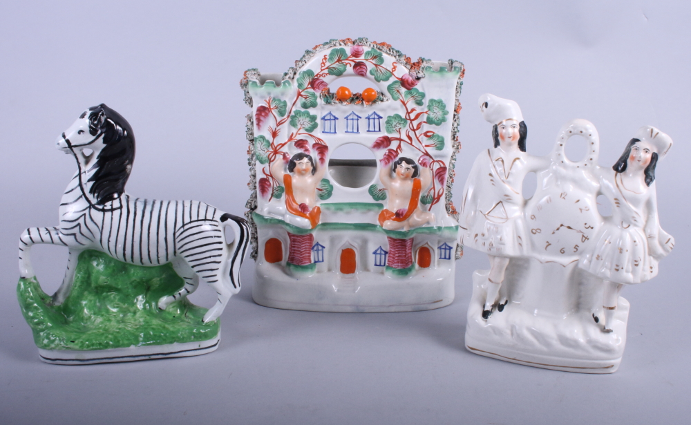 A Staffordshire model of a zebra, a Burns and Mary watch group and one other watch holder with