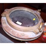 An early 20th century ship's brass circular porthole