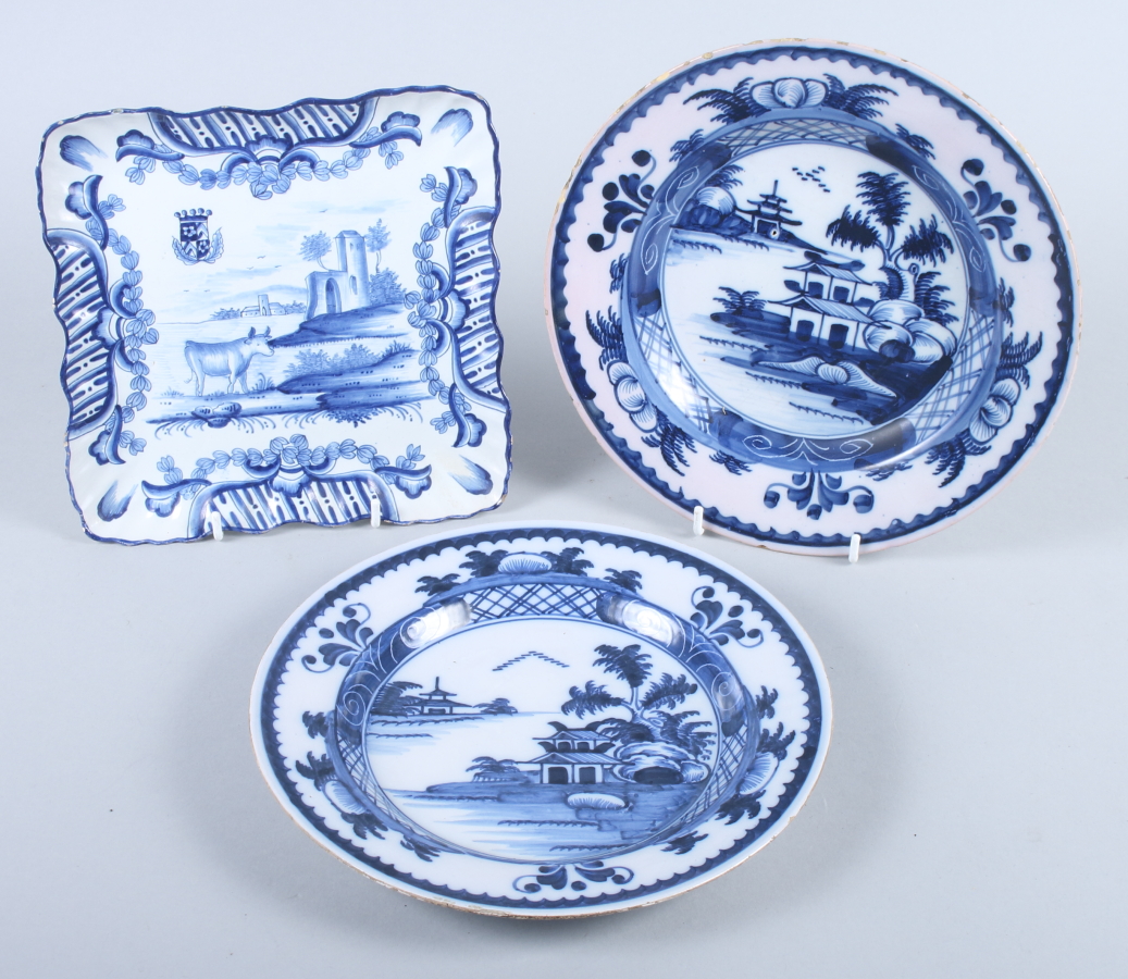 A Delft square dish, decorated cows and castle, 8" square, and a pair of Delft plates, decorated