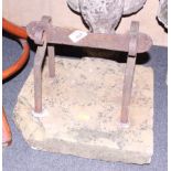 A metal boot scraper, on square stone base