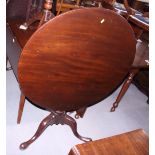 A Georgian mahogany circular tilt top table, on turned column and tripod splay support with pad