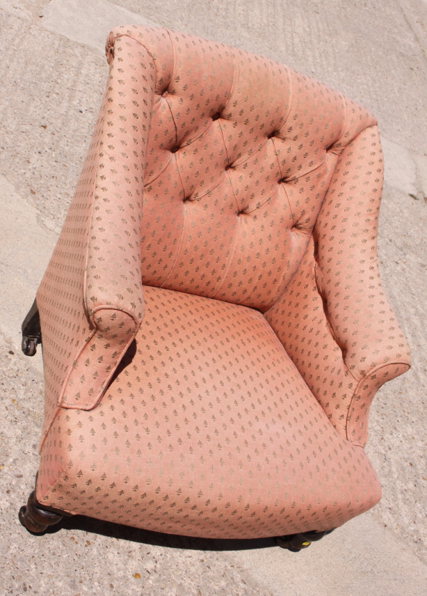 A Victorian low armchair with button back, upholstered in a pink fabric