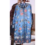 A Chinese embroidered silk robe with floral and insect decoration on a blue ground