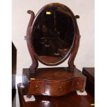 A Georgian mahogany serpentine front dressing table mirror with three drawer base, on squat bun feet