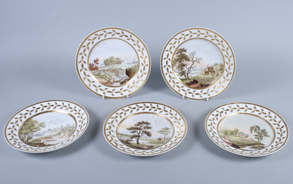 A set of five 19th century French porcelain plates, with landscapes within a gilt painted leaf