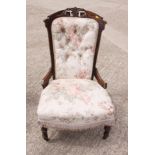 A Victorian stained frame nursing chair, upholstered in a floral print fabric