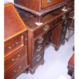 A late 18th century provincial oak kneehole desk, fitted eight drawers and central cupboard, on