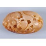 A Chinese carved mottled hardstone pebble with fan-tail fish decoration, 3 1/2" long