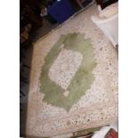 A Chinese design carpet in shades of green and ivory with a floral border, 12' x 9' approx