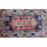 A Turkish rug with blue medallion on a pink ground, 77" x 48" approx