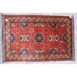 A modern Turkmen rug with star design on a red ground, 60" x 39" approx