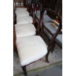 A set of five early Victorian rosewood balloon back dining chairs with scroll carved top rails,