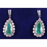 A pair of 18ct gold drop earrings, set central pear cut emerald, flanked diamonds in brilliant and