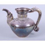 An early 20th century Indian white metal hot water pot with cast serpent handle, elephant trunk