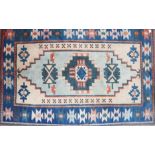 A Kazak rug with cream ground and blue star borders, 72" x 48" approx