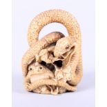A Meiji period carved ivory okimono, in the form of a snake entwining a bull frog, signed to base, 2