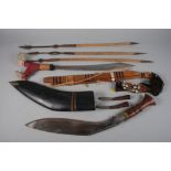 A Dayak parang and scabbard, a kukri with scabbard and skinning knives, and three short spears