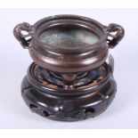 A Chinese 18th century bronze two-handled censer, the handles cast in the form of mythical
