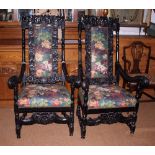 A pair of ebonised elbow chairs of Restoration design with floral padded seats and backs, on