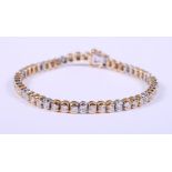 An 18ct two colour gold tennis bracelet set fifty-one brilliant cut diamonds, each stone .06ct