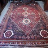 A Persian tribal rug of traditional design with central medallions on a blue ground with birds,