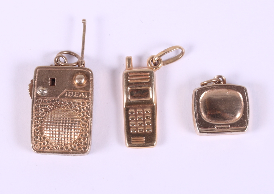 Three 9ct gold pendants, in the form of a telephone, a television and a radio, 8g