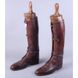 A pair of brown leather riding boots with associated boot trees