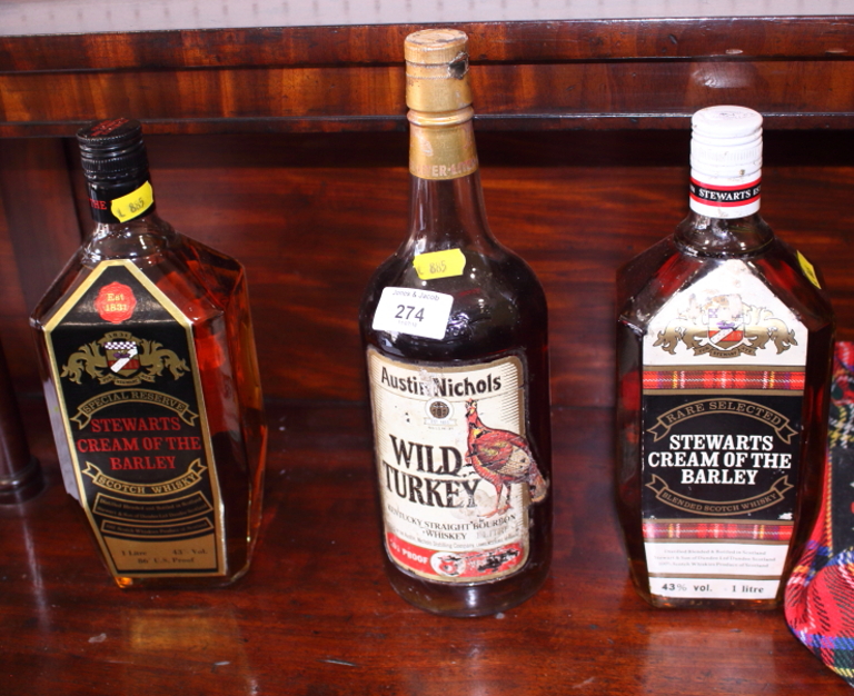 Two bottles of Stewarts Cream of the Barley Scotch whisky, a bottle of Wild Turkey Bourbon whiskey