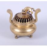 A Chinese brass two-handled censer, the pierced lid with Kylin surmount, on three dragon mask