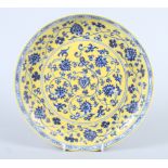 A Chinese Ming design dish with blue floral decoration on a yellow ground, the reverse with
