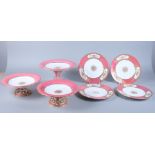 A late 19th century bone China dessert service with bird and floral reserve panels on a pink and